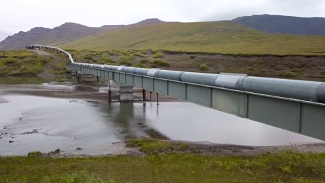 trans-alaska pipeline system over river in alaska countryside - aerial drone