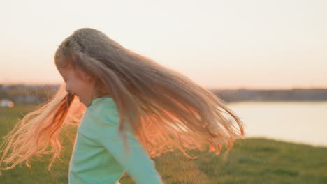 chica feliz jugando en un campo al atardecer