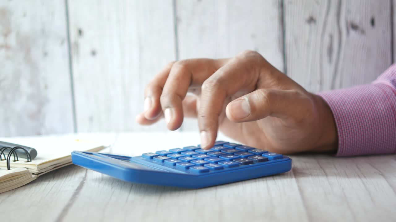 Cerca de contador con calculadora en el escritorio de oficina.