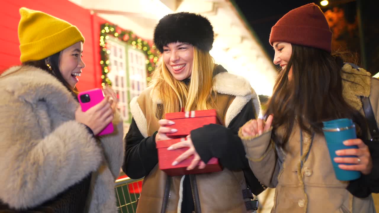 Three women exchanging gifts during winter