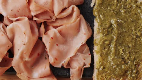 ham italian mordatella, man slices of traditional italian antipasti mortadella sausage on a wooden cutting board, close up macro of chicken or turkey jamon, fat breakfast dish.
