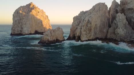 tropical waters and cliff of cabo san lucas at sunset