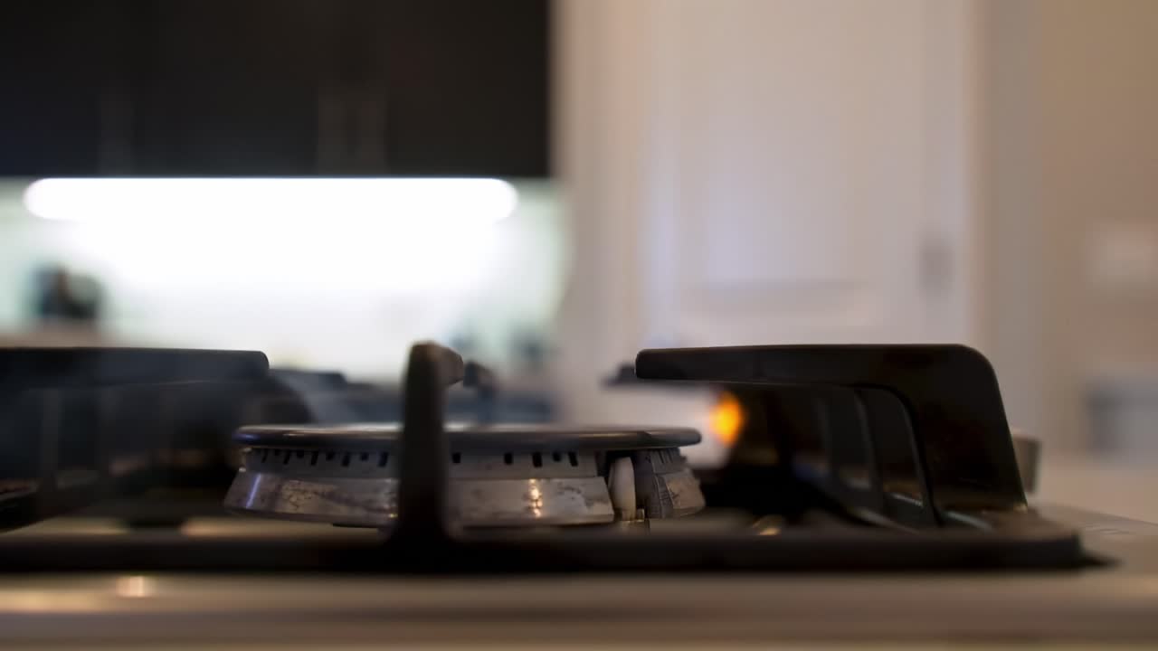 Capturing the Transition: A Gas Burner Ignites Brightly, Signifying the Beginning of a Culinary Journey in a Modern Kitchen Setting