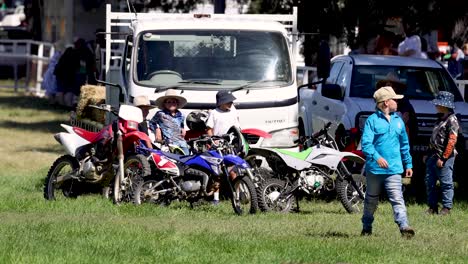 niños interactuando cerca de motocicletas y vehículos