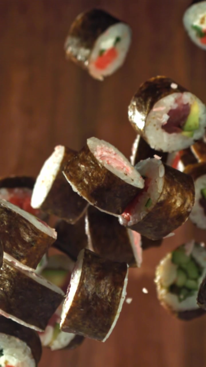 Sushi roll giapponesi assortiti che cadono al rallentatore