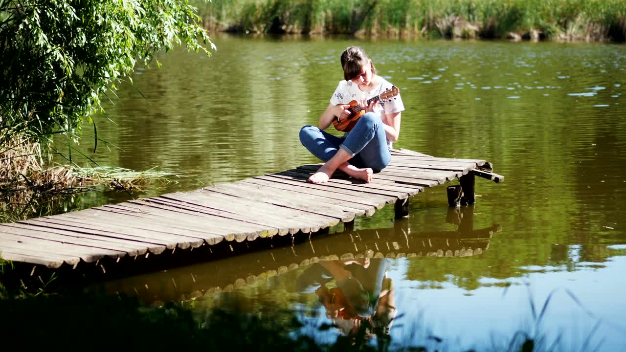 우쿨레레 기타를 연주하는 아름다운 소녀