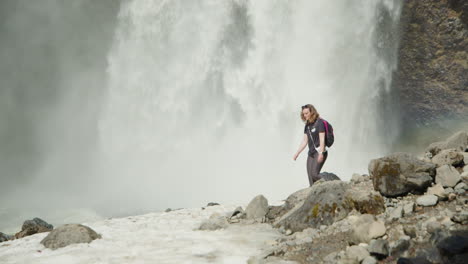 Woman-walking-near-Moul-Falls-on-sunny-day,-Canada