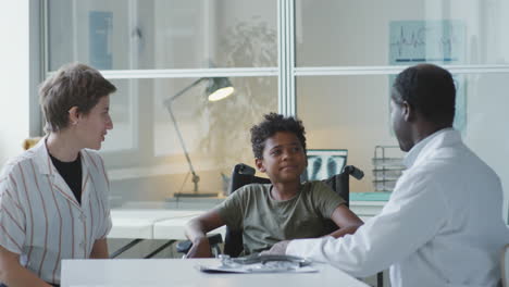 doctor consulting with young patient and mother