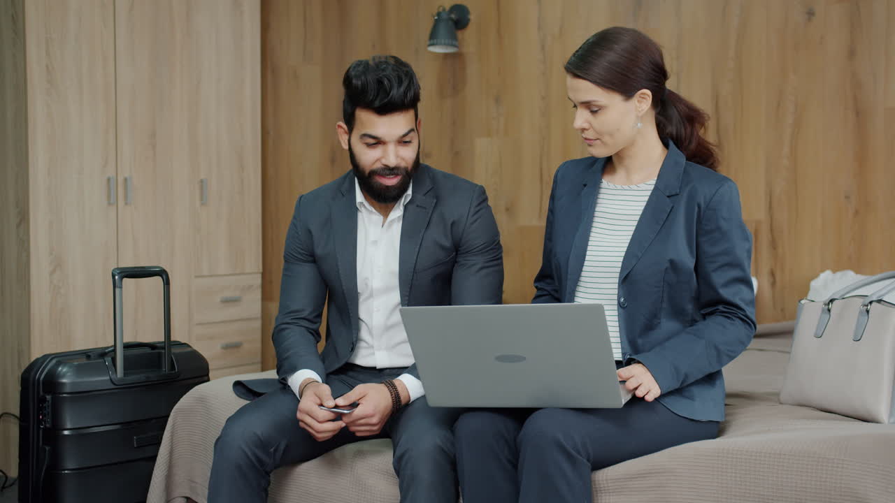 Business Couple Discussing Travel Plans in Hotel Room