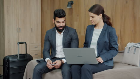 business couple discussing travel plans in hotel room