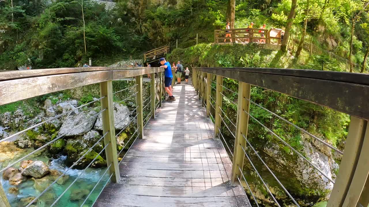 木の橋とハイカーがいる川の峡谷