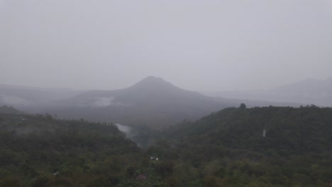 serene view of kintamani, bali, indonesia, during foggy rain with majestic mountains in the background. a tranquil and atmospheric landscape showcasing nature's beauty in tropical highlands.