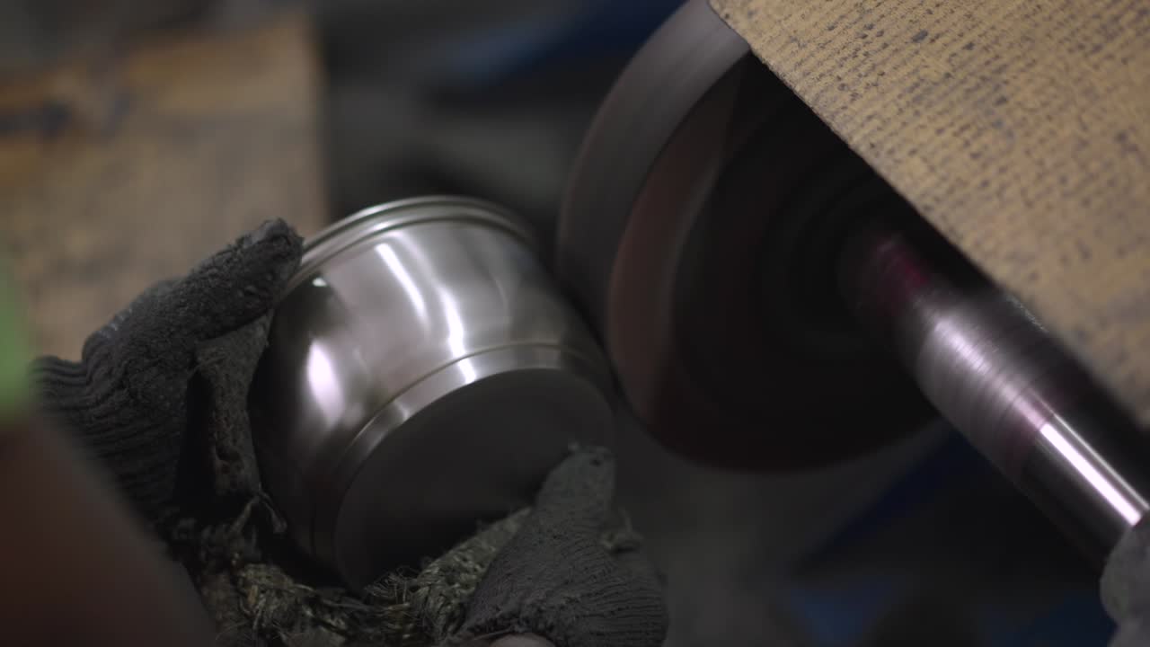 Using a belt sander to produce steel pan cookware in a factory