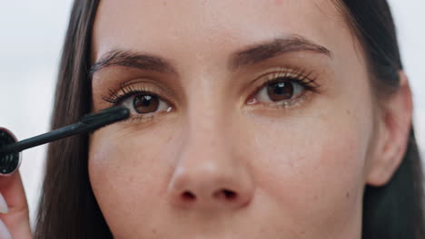 closeup woman colouring eyelashes indoor. portrait lady applying mascara makeup