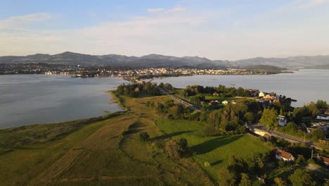 Drohnenaufnahme-Aus-Der-Luft,-Die-Rückwärts-Fliegt-Und-Rapperswil-Und-Hurden-Während-Eines-Sommersonnenuntergangs-Enthüllt