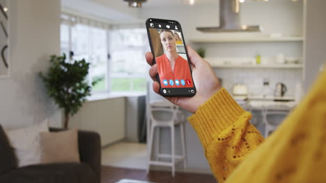 mujer teniendo una reunión de video en su teléfono inteligente en casa