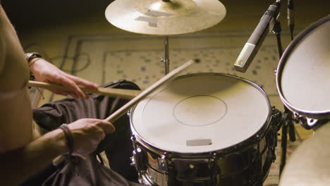 joven baterista tocando la batería en un estudio de música