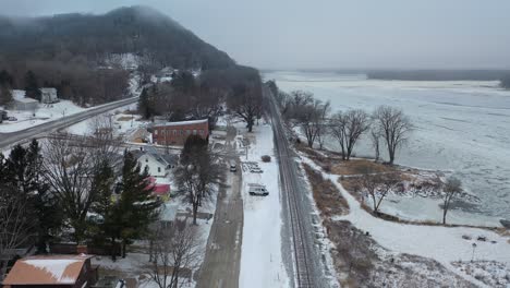snowy city street scene with parking lot and train tracks