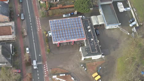 jib down of gas station with solar panels on rooftop - close