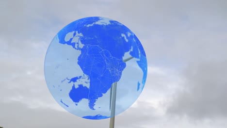 Animation-of-globe-over-wind-turbine-against-sky
