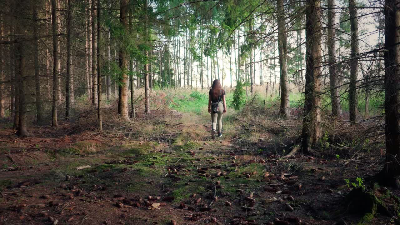 Young girls with long hair walking in the forest in slow motion