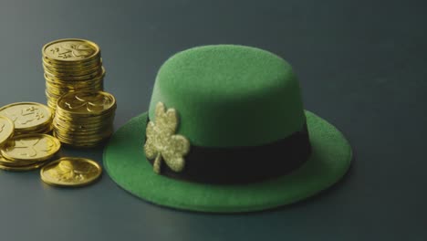 studio shot of green leprechaun top hat and piles of gold coins to celebrate st patricks day