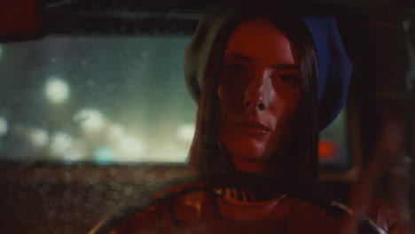portrait of beautiful woman driving retro car in rainy night