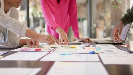 african american colleagues with documents and graphs on table discussing work, slow motion