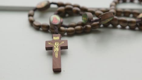 close up tilt down and pan left of wooden rosary beads