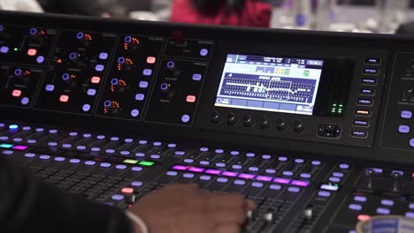 real sound maestro navigates the mixing board at a live event checking audio levels