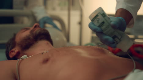 doctor hands defibrillating patient in hospital emergency facility close up.