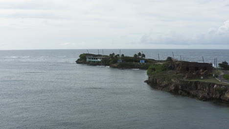 Aerial-push-in-footage-of-Isla-de-Cabra,-once-a-Leper-Colony-on-the-island-now-a-recreation-park