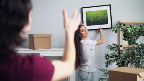 couple hanging a picture during a move