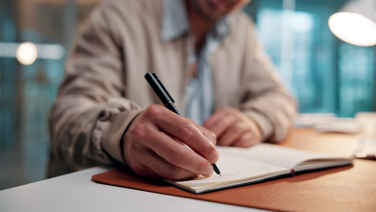 Close-Up of a Person's Hand Writing in a Notebook