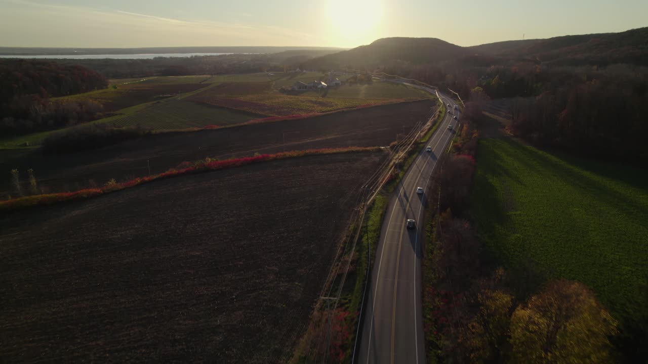 Casa de fazenda ao pôr do sol localizada perto de uma estrada longa e reta
