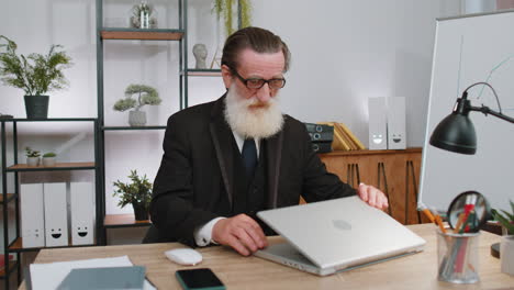 senior business man freelancer at office, start working on laptop computer, sends online messages