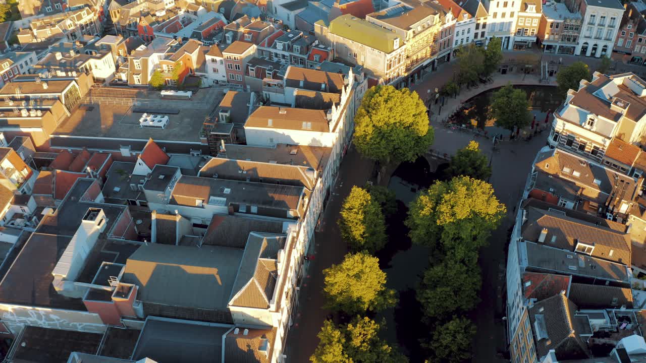 Beautiful aerial top down view of oudegracht medieval historic city canals of Utrecht in the Netherlands and tilt up to modern city downtown and skyscrapers