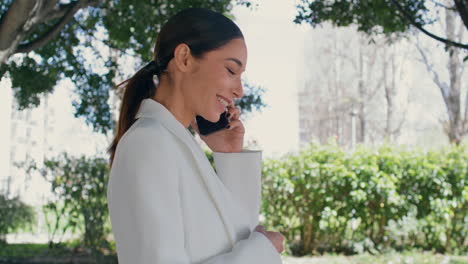 smiling business lady calling phone walking park closeup. girl talking telephone