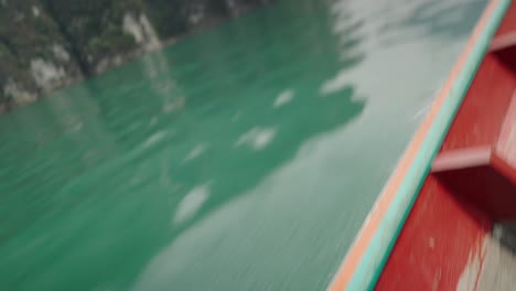 Tourist woman using phone on a traditional boat ride amidst scenic mountains and lake