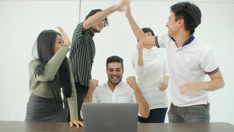 happy diverse casual creative business team are working hard to complete a business deal. they celebrate when they discover that they have been successful