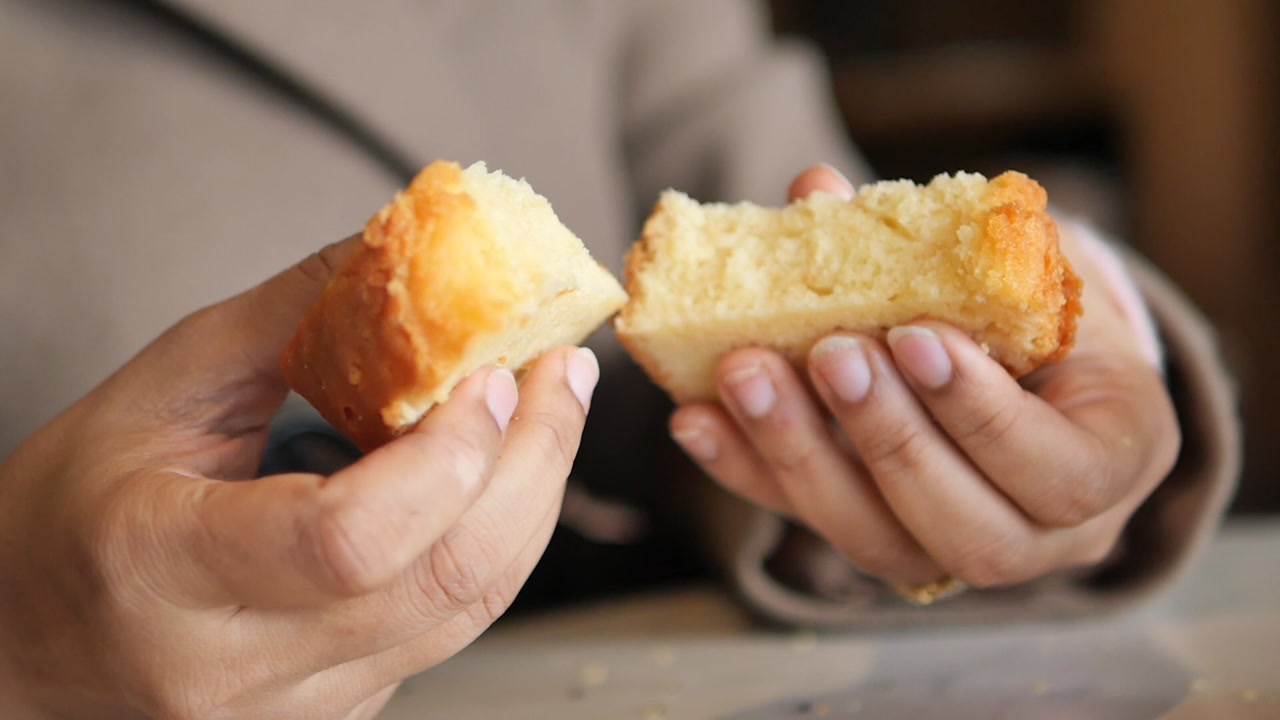 Close-up of Hands Breaking a Piece of Cake