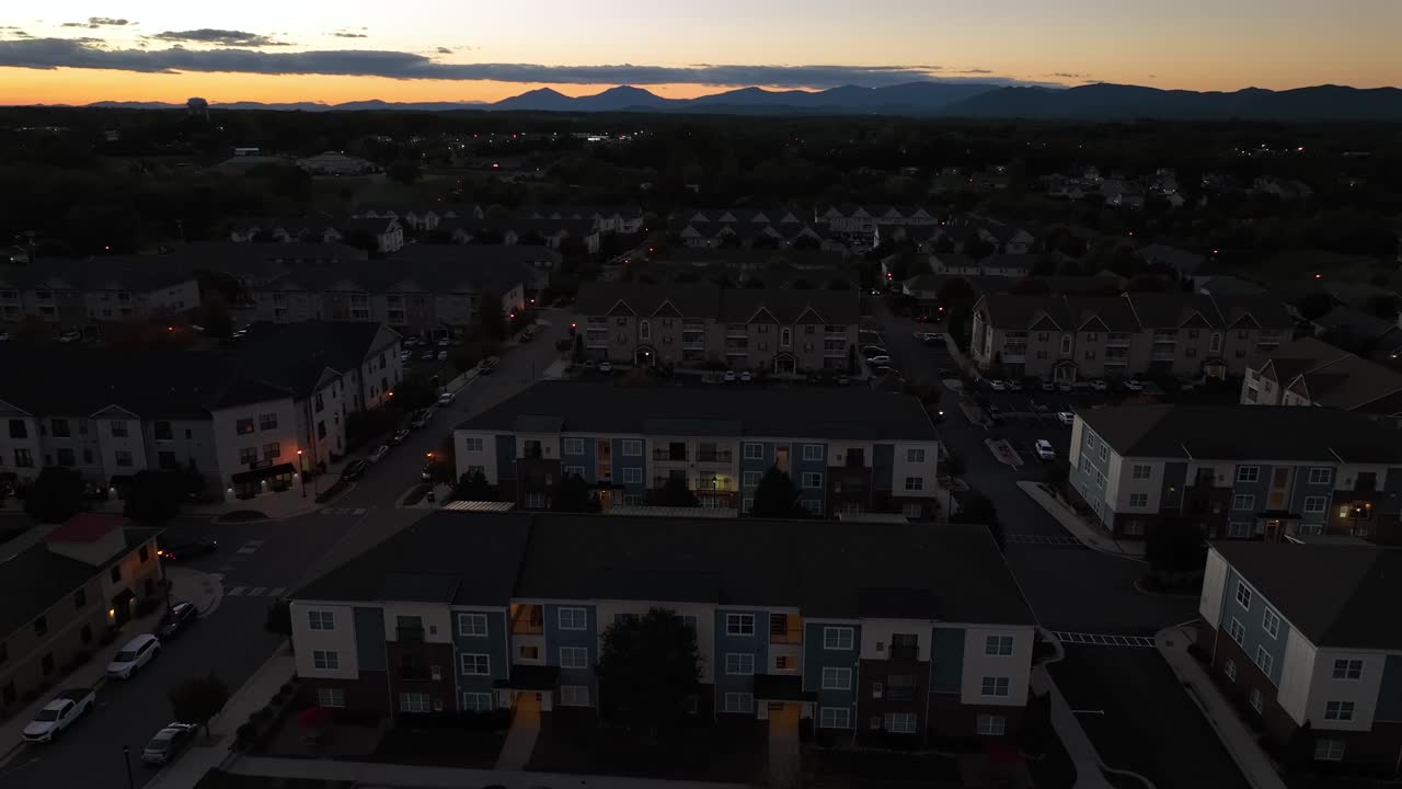 Peaceful Residential area with townhouses and apartment buildings at dusk. Aerial wide shot. Silhouette of blue ridge mountains in distance. Virginia, USA in autumn season
