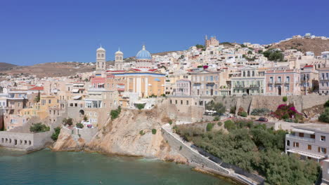 aerial: flying over saint nicholas church in ermoupoli of syros island, greece on a sunny day