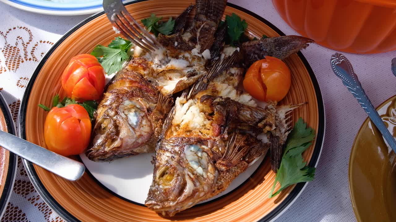 comer pescado de agua dulce saludable y quitar carne blanca suculenta con un tenedor de la pesca fresca del día presentada en un plato colorido con guarnición