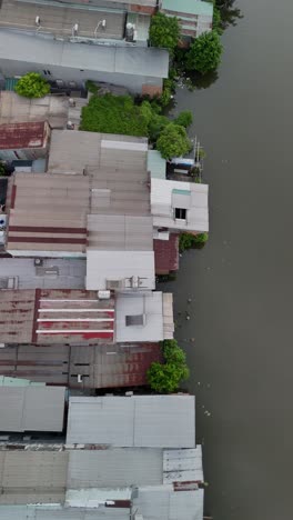 waterfront view of urban saigon canal in ho chi minh city at sunset featuring shanty houses and road at sunset