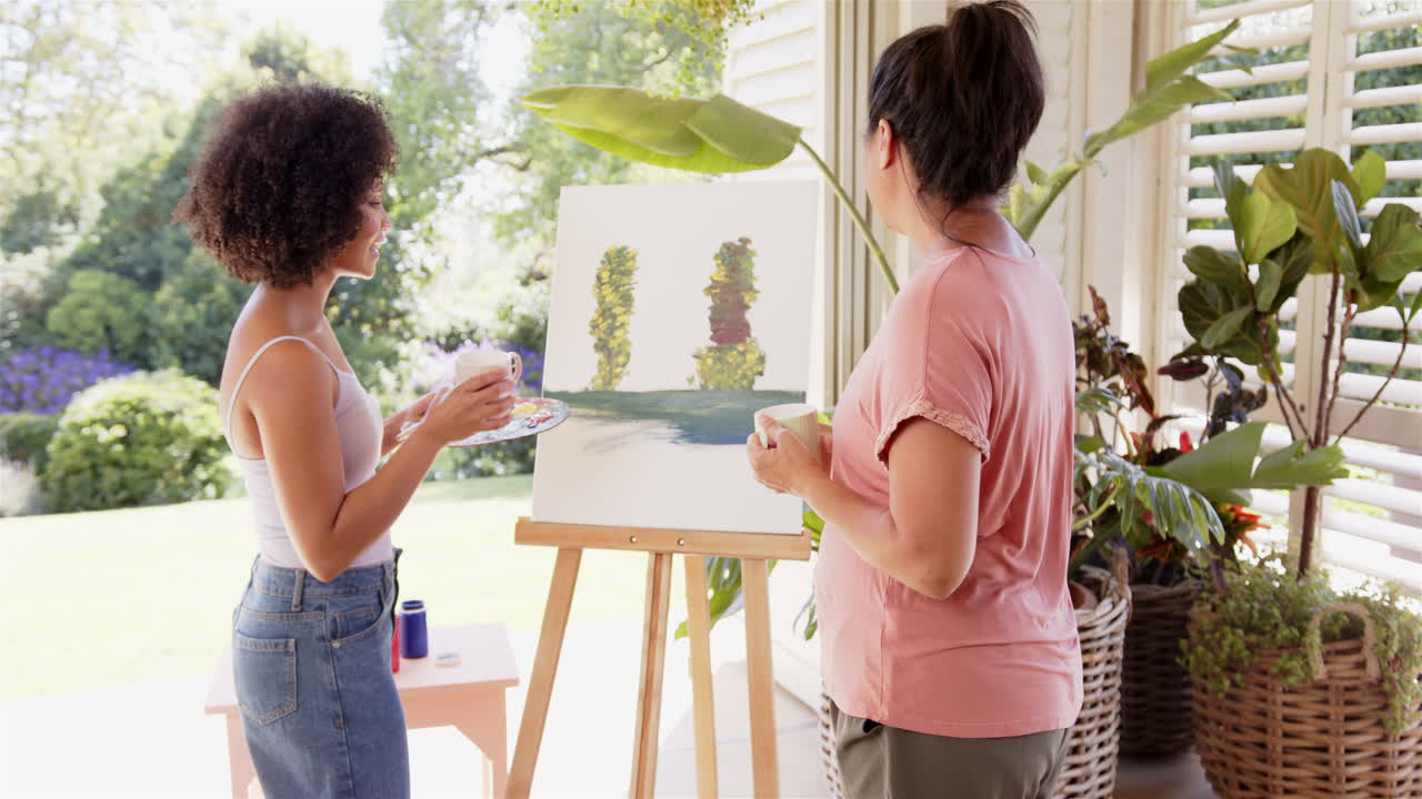 Painting together, women enjoying outdoor art session with canvas and brushes