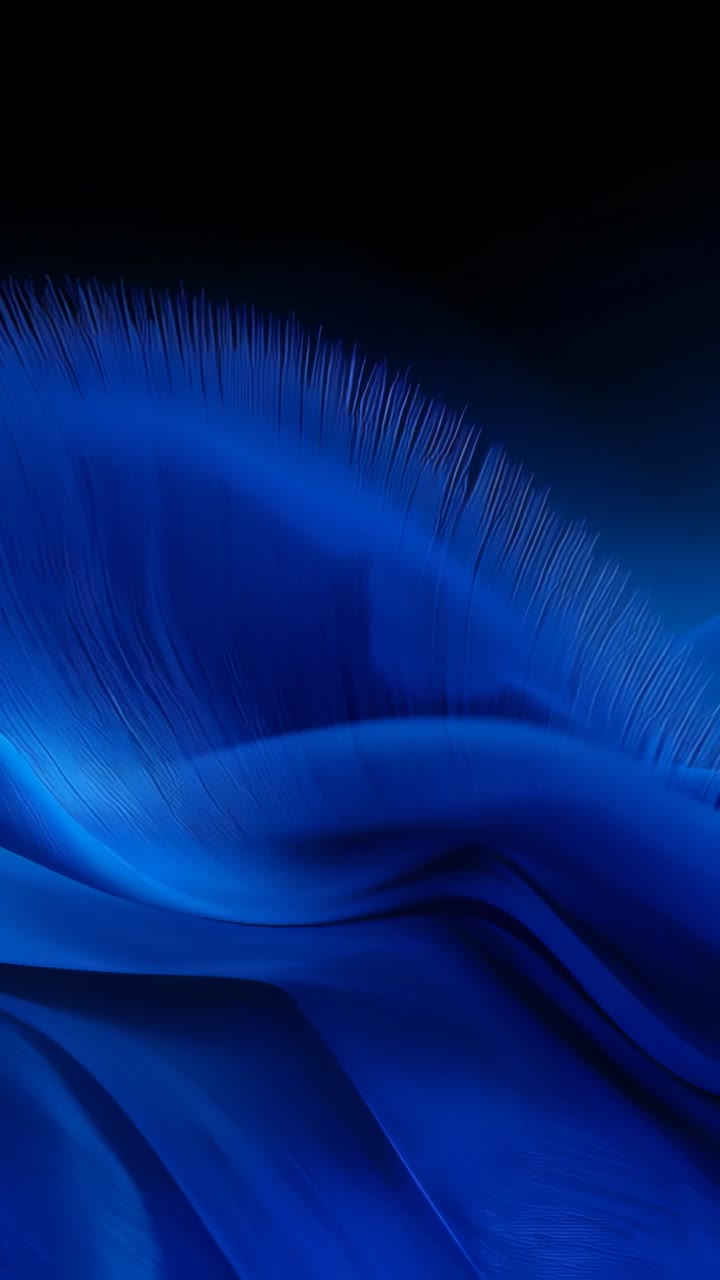 Video verticale: Forma di tessuto blu animata che si dispiega e si sposta verso l'alto per rivelare filamenti in un vuoto oscuro.