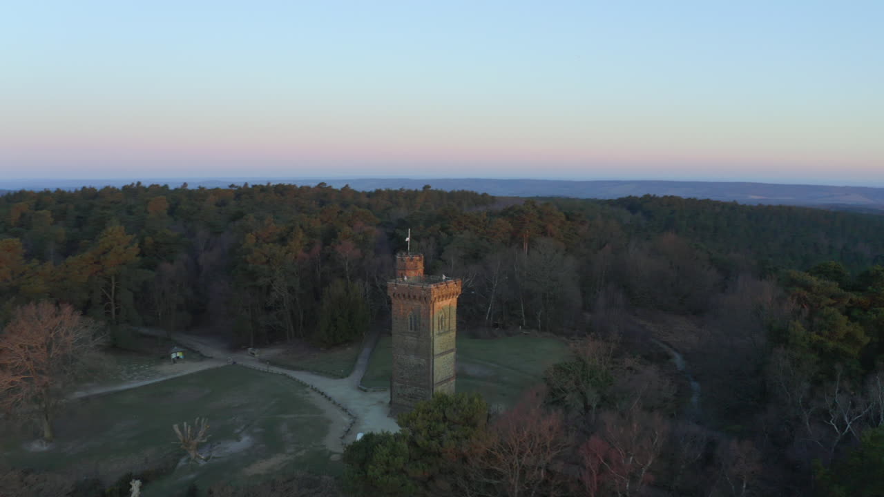 Smooth aerial drone footage circling Leith Hill tower in the Surrey Hills, in the English countryside