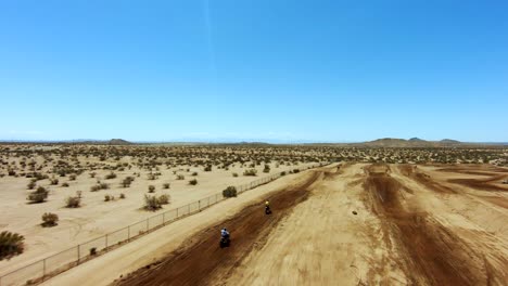 carrera de motos todoterreno de alta velocidad en un campo de tierra del desierto - vista aérea en cámara lenta