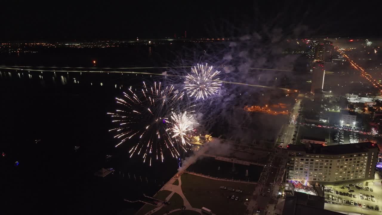 espectacular espectáculo de fuegos artificiales estallando a lo largo de la costa de fort myers con el puente edison en el fondo, florida en estados unidos